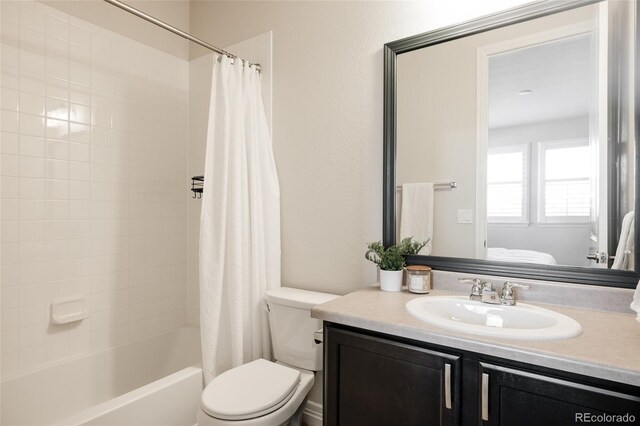 bathroom featuring toilet, shower / tub combo with curtain, and vanity