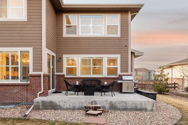 back of house with brick siding and a patio area