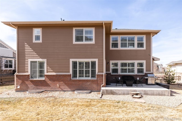 back of property featuring brick siding and a patio