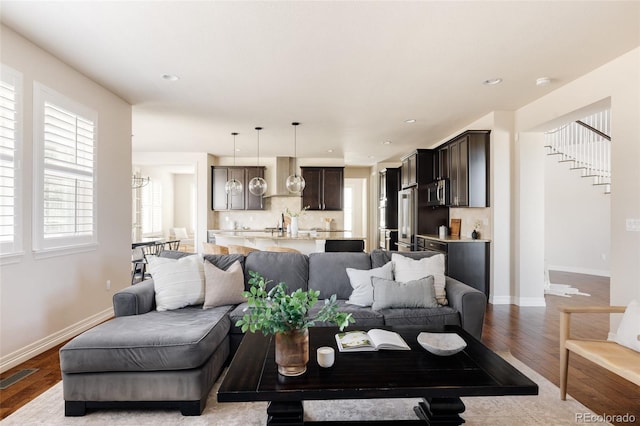 living room with recessed lighting, wood finished floors, visible vents, and baseboards