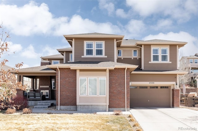 prairie-style house featuring concrete driveway, a garage, brick siding, and covered porch