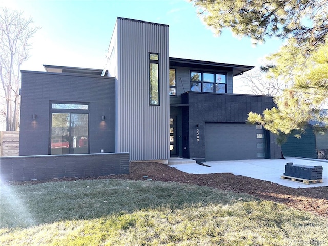 contemporary house featuring a garage and a front lawn