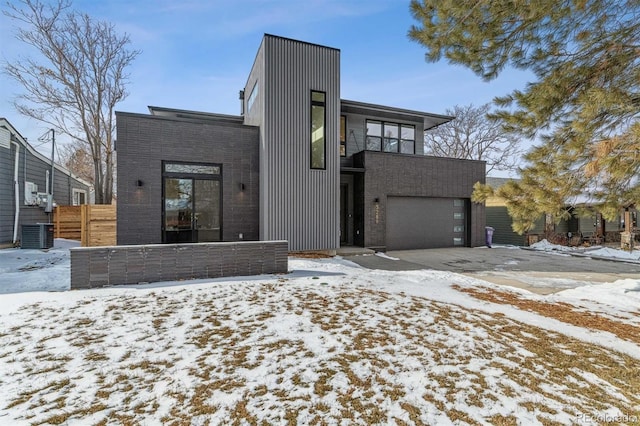 contemporary home with a garage and central air condition unit