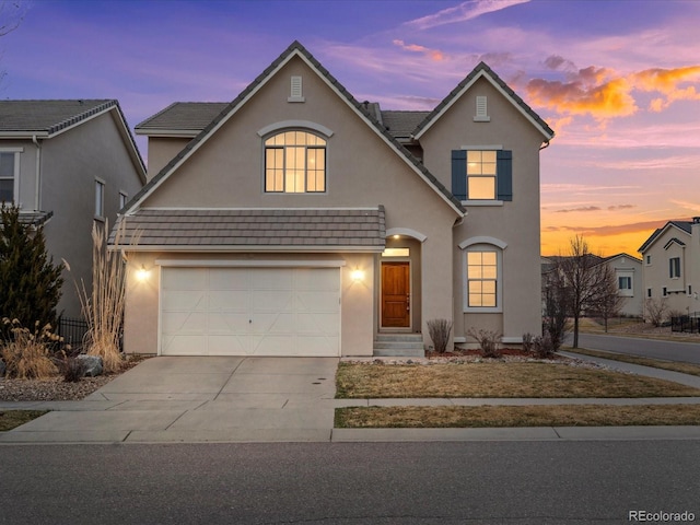 traditional-style home featuring stucco siding and concrete driveway