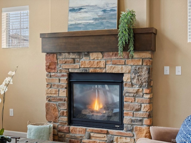 details with a stone fireplace and baseboards