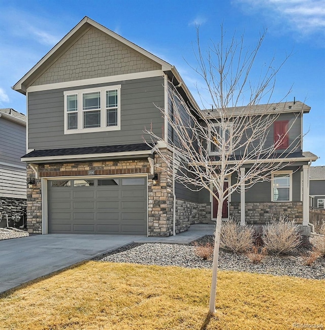 view of front of home with concrete driveway, a garage, stone siding, and a front yard