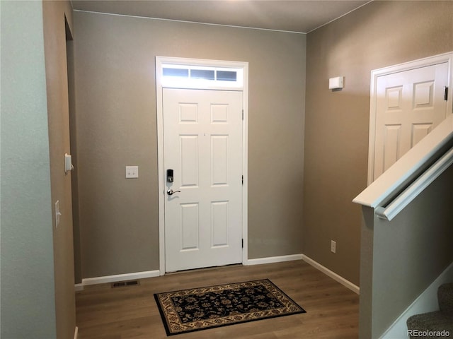 entryway with stairway, wood finished floors, visible vents, and baseboards