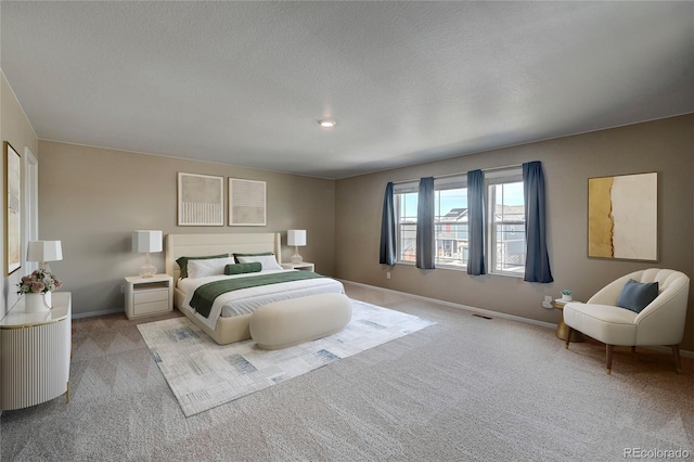 carpeted bedroom featuring baseboards and a textured ceiling