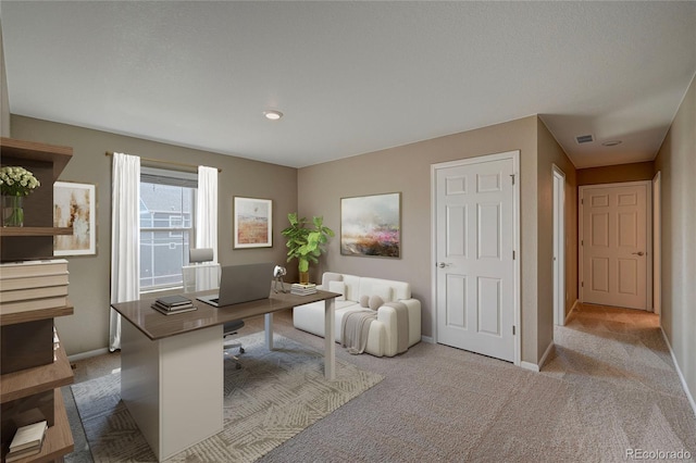 carpeted office space with visible vents and baseboards