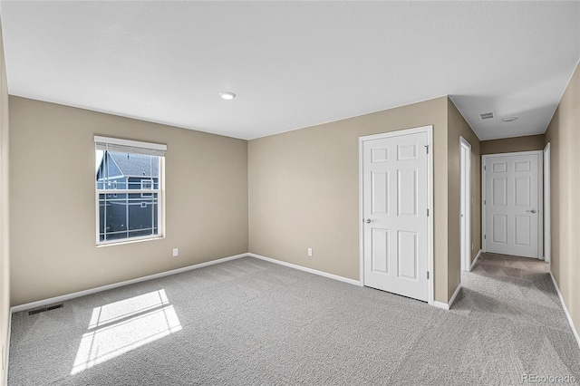 unfurnished bedroom with visible vents, baseboards, and carpet