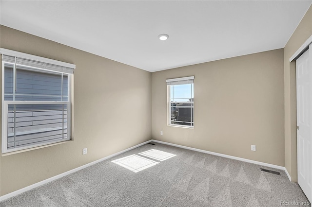 unfurnished bedroom with baseboards, carpet floors, visible vents, and a closet