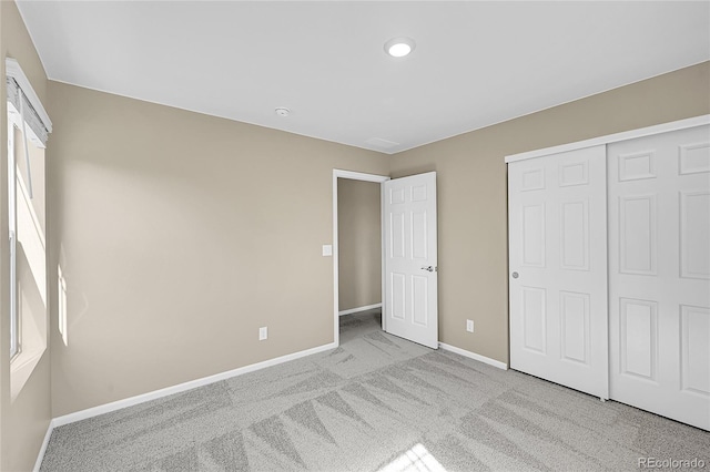 unfurnished bedroom featuring a closet, baseboards, and carpet floors