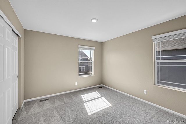 unfurnished bedroom featuring visible vents, carpet, a closet, and baseboards