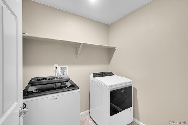 clothes washing area featuring washer and dryer, baseboards, and laundry area