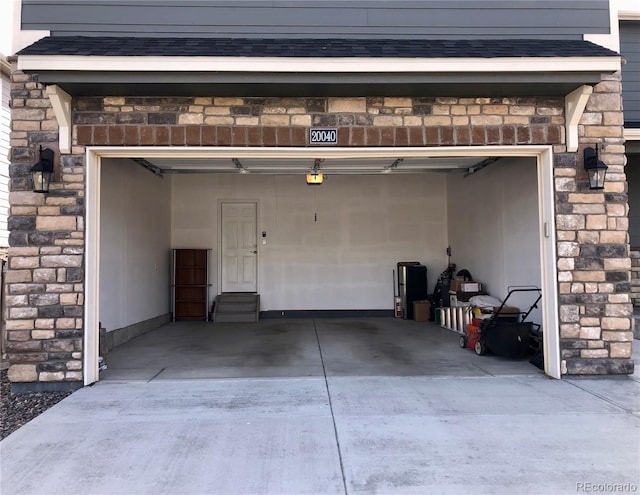 garage with concrete driveway and a garage door opener