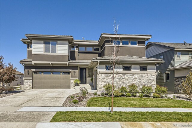 16345 Spanish Peak Way, Broomfield, CO 80023 - prairie-style home featuring stone siding, stucco siding, an attached garage, and driveway