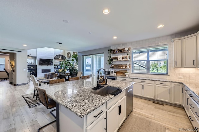 16345 Spanish Peak Way, Broomfield, CO 80023 - kitchen with a sink, dishwasher, a kitchen breakfast bar, recessed lighting, and tasteful backsplash