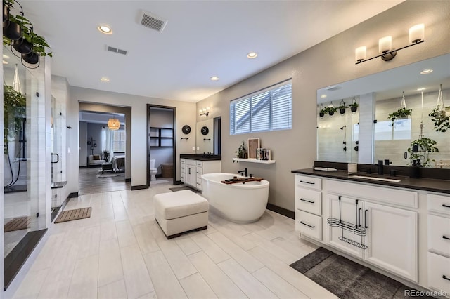 16345 Spanish Peak Way, Broomfield, CO 80023 - full bath with a shower stall, two vanities, a soaking tub, recessed lighting, and baseboards