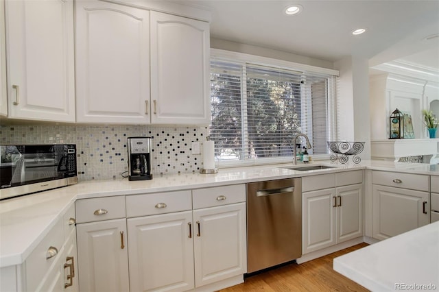 kitchen featuring sink, decorative backsplash, stainless steel dishwasher, and white cabinets