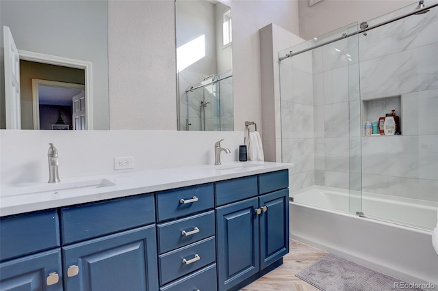 bathroom featuring hardwood / wood-style flooring, vanity, and combined bath / shower with glass door