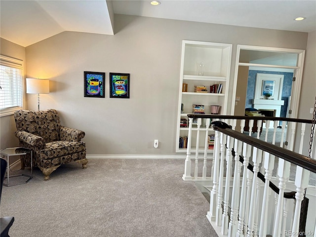 living area with vaulted ceiling, carpet flooring, and built in features