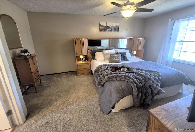 bedroom with light carpet, ceiling fan, and a textured ceiling