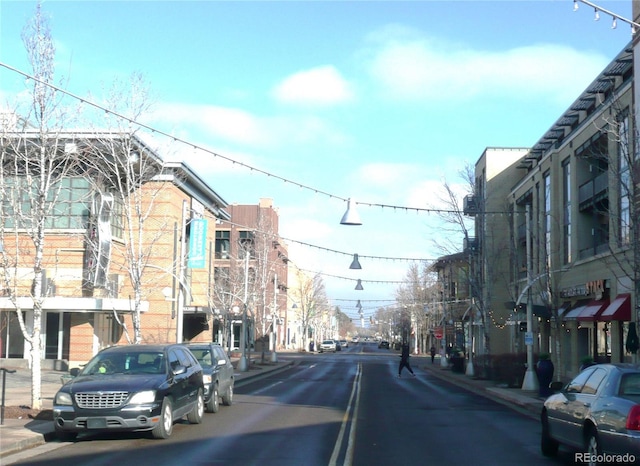 view of road featuring sidewalks, street lights, and curbs