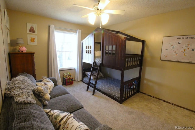 bedroom with ceiling fan, light carpet, and a textured ceiling