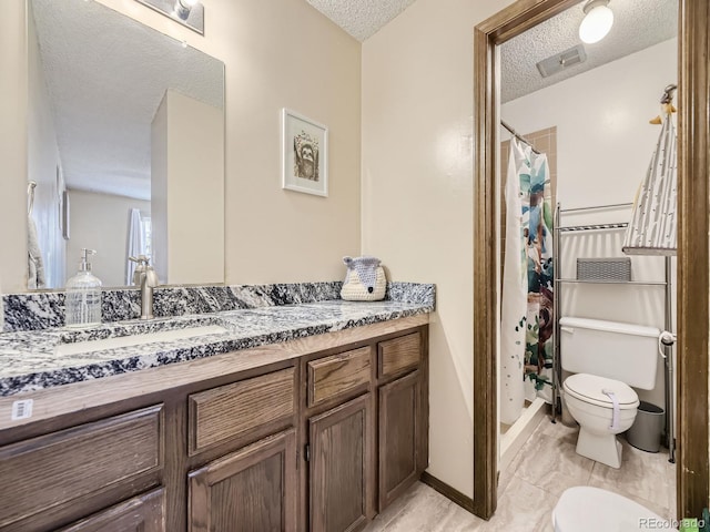 bathroom with vanity, visible vents, a stall shower, toilet, and a textured ceiling