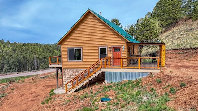 18766 State Highway 67, Divide, CO 80814 - rear view of property featuring faux log siding, stairway, a view of trees, and stone siding