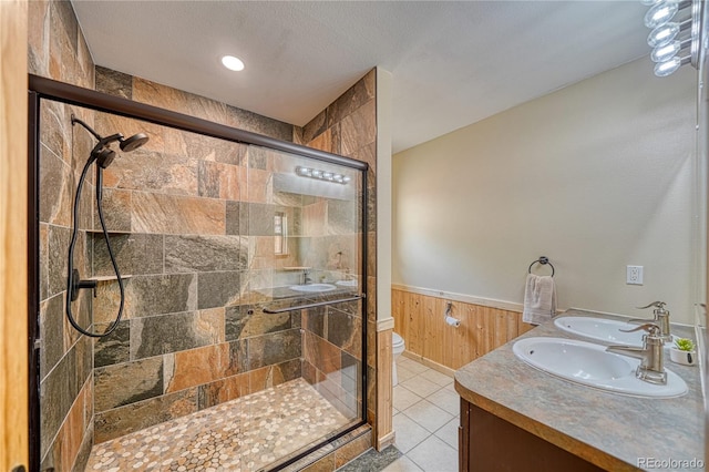 18766 State Highway 67, Divide, CO 80814 - bathroom with a stall shower, toilet, double vanity, wainscoting, and tile patterned floors