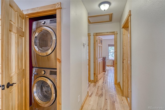 18766 State Highway 67, Divide, CO 80814 - washroom featuring estacked washer and dryer, light wood finished floors, attic access, and baseboards