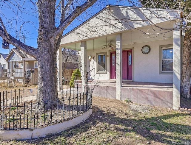 exterior space with ceiling fan, fence, covered porch, and stucco siding