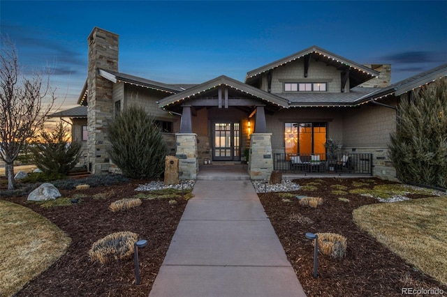 3947 Taliesin Way, Fort Collins, CO 80524 - view of front facade with a porch, stone siding, and a chimney