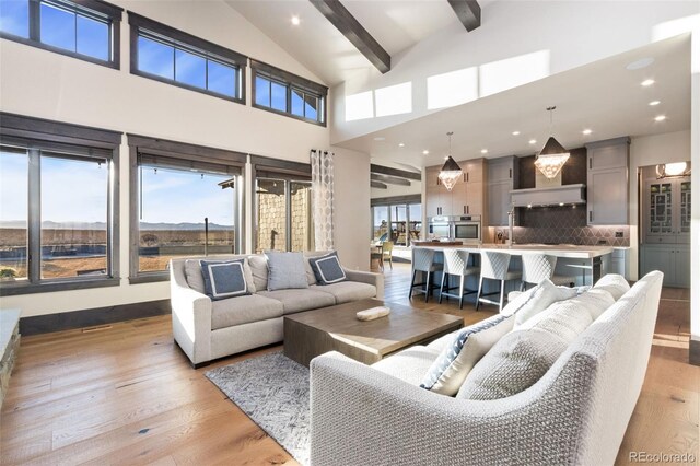 3947 Taliesin Way, Fort Collins, CO 80524 - living room with recessed lighting, beam ceiling, light wood-style floors, and high vaulted ceiling