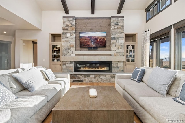 3947 Taliesin Way, Fort Collins, CO 80524 - living area with wood finished floors, beam ceiling, a stone fireplace, and a towering ceiling