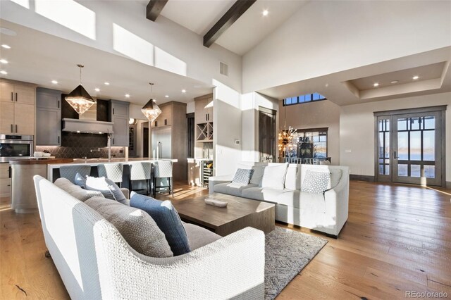 3947 Taliesin Way, Fort Collins, CO 80524 - living room with visible vents, beamed ceiling, high vaulted ceiling, a notable chandelier, and light wood-style floors