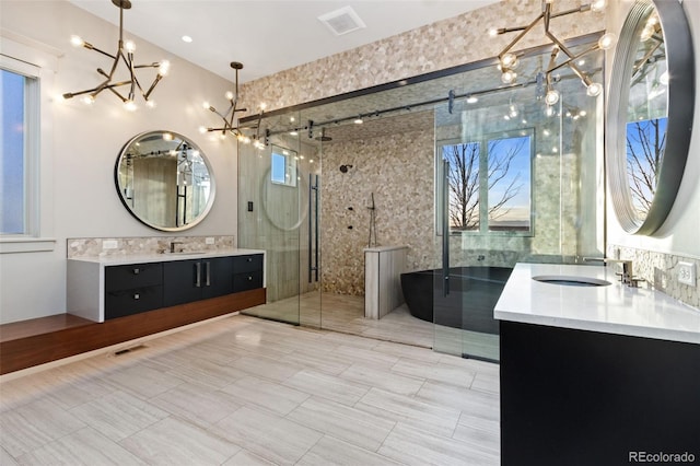 3947 Taliesin Way, Fort Collins, CO 80524 - bathroom featuring visible vents, an inviting chandelier, two vanities, a stall shower, and a sink
