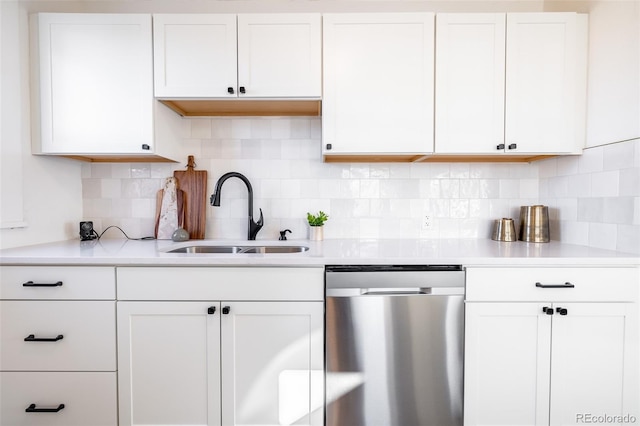 kitchen featuring white cabinets, dishwasher, sink, and tasteful backsplash