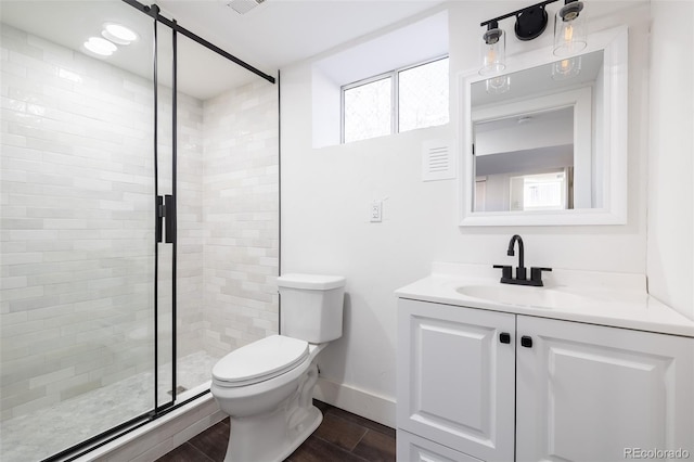 bathroom with an enclosed shower, hardwood / wood-style flooring, vanity, and toilet