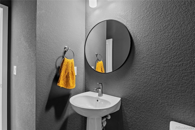 bathroom with a sink and a textured wall