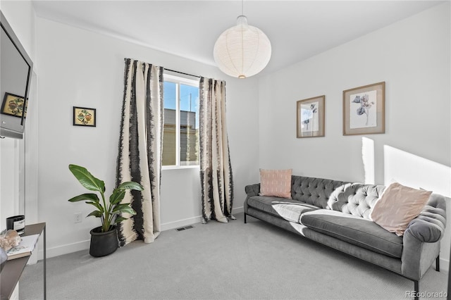 carpeted living area featuring baseboards and visible vents