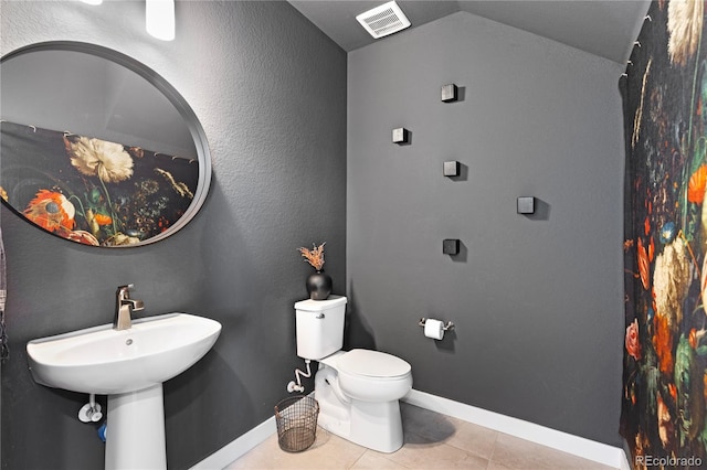 bathroom with visible vents, baseboards, toilet, lofted ceiling, and tile patterned floors