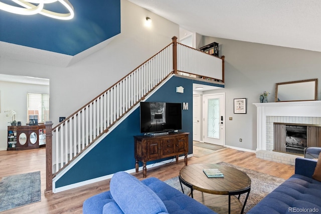 8997 W 88th Ave, Westminster, CO 80021 - living room with high vaulted ceiling, wood finished floors, and a brick fireplace