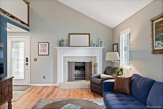 8997 W 88th Ave, Westminster, CO 80021 - living area with lofted ceiling, wood finished floors, and a brick fireplace