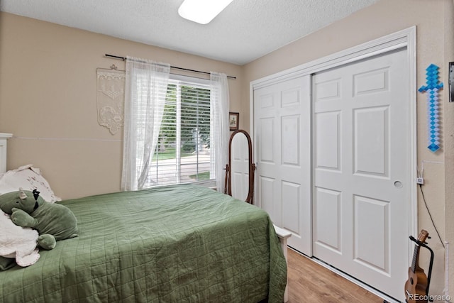 8997 W 88th Ave, Westminster, CO 80021 - bedroom featuring light wood finished floors, a textured ceiling, and a closet
