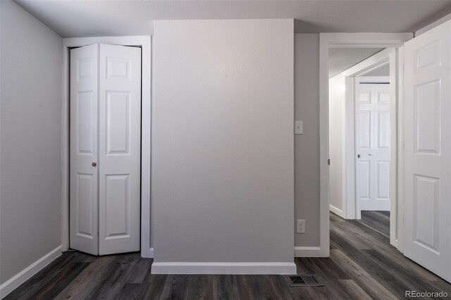 530 Illinois St, Penrose, CO 81240 - unfurnished bedroom featuring dark hardwood / wood-style flooring and a closet