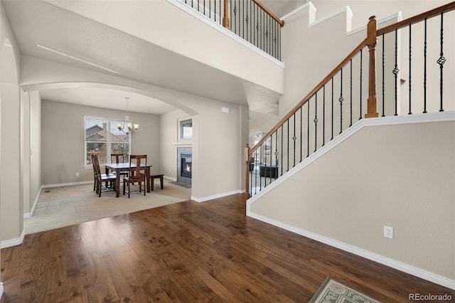 1053 Crystal Basin Dr, Colorado Springs, CO 80921 - entryway with arched walkways, wood finished floors, stairs, and a chandelier