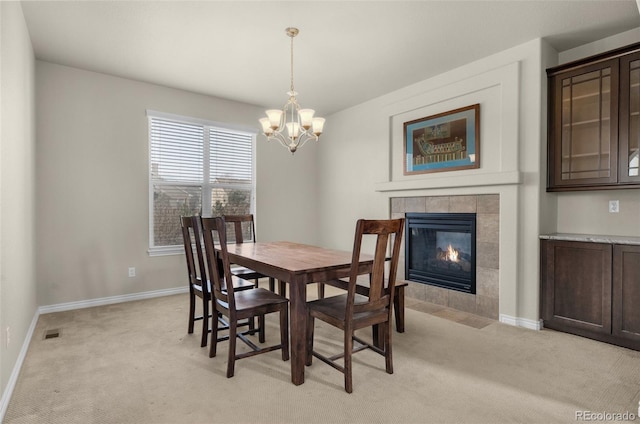 1053 Crystal Basin Dr, Colorado Springs, CO 80921 - dining area featuring light colored carpet, a chandelier, and a tiled fireplace