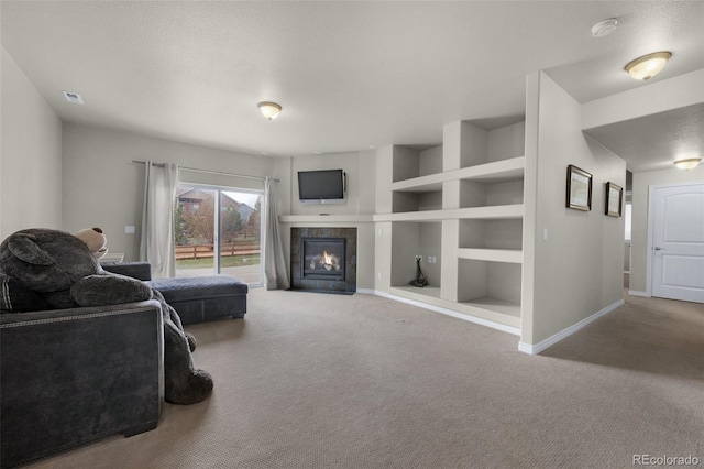 carpeted living room featuring built in shelves, a textured ceiling, and a tiled fireplace